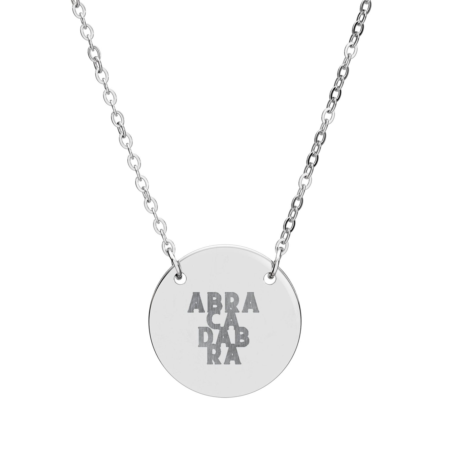 Silver necklace with a round pendant engraved with 'ABRACADABRA' on a white background
