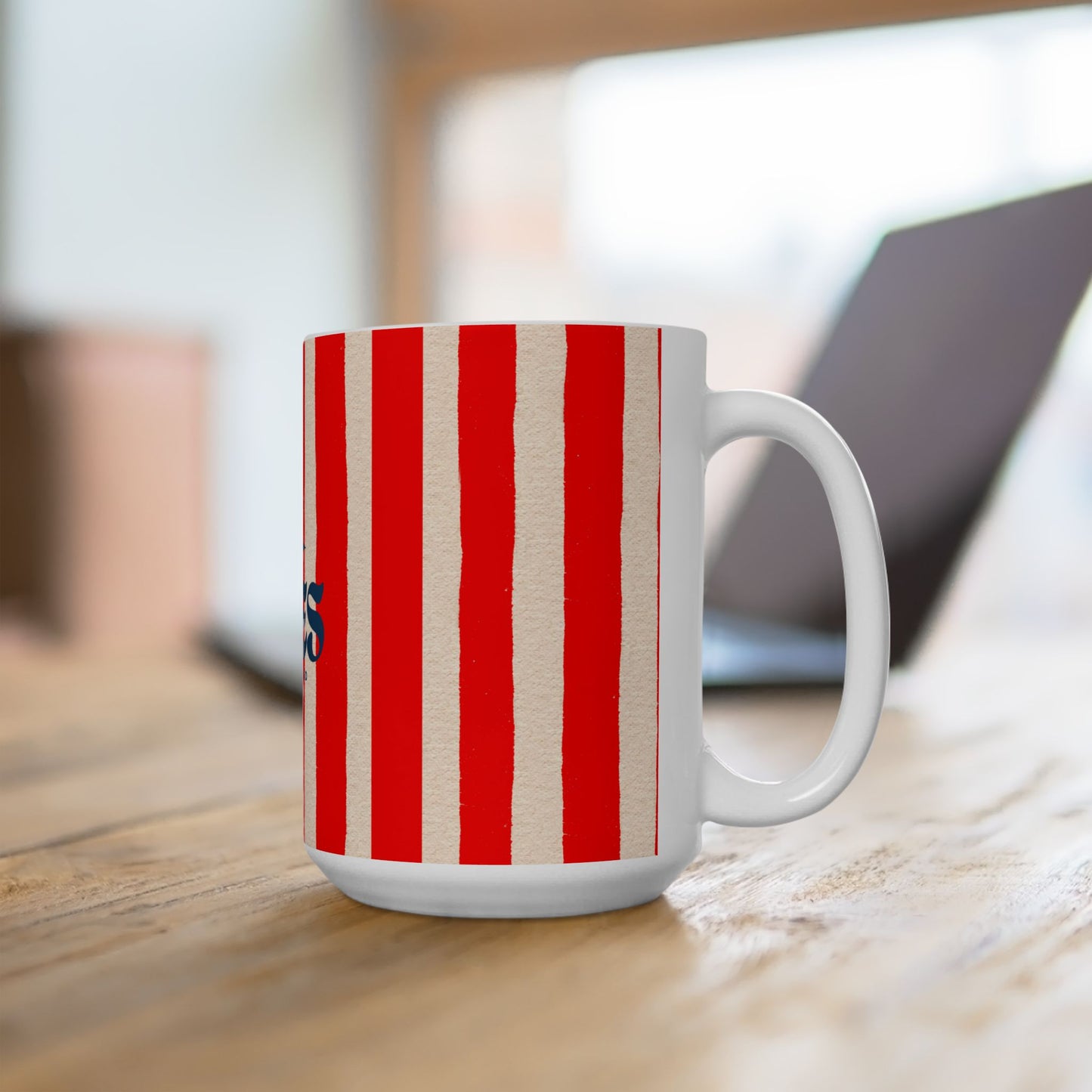 White mug with red and beige stripes on a wooden surface