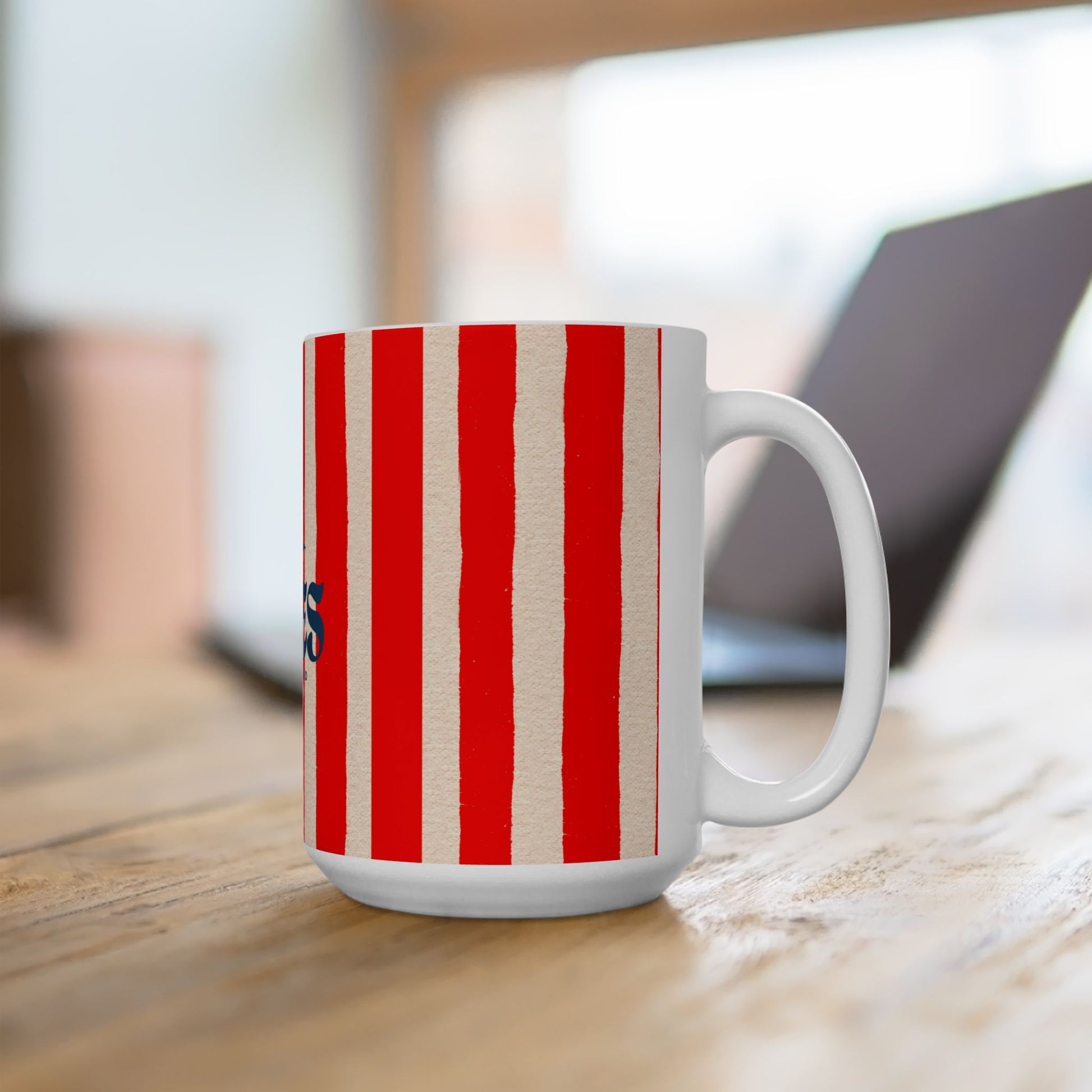 White mug with red and beige stripes on a wooden surface