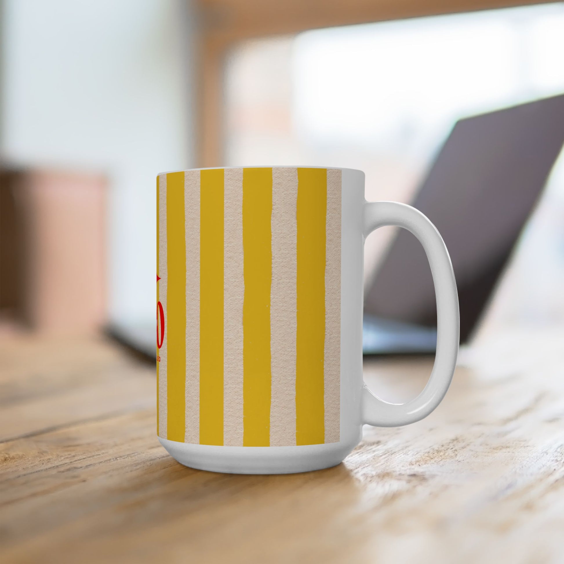 White mug with yellow and red striped pattern on a wooden surface