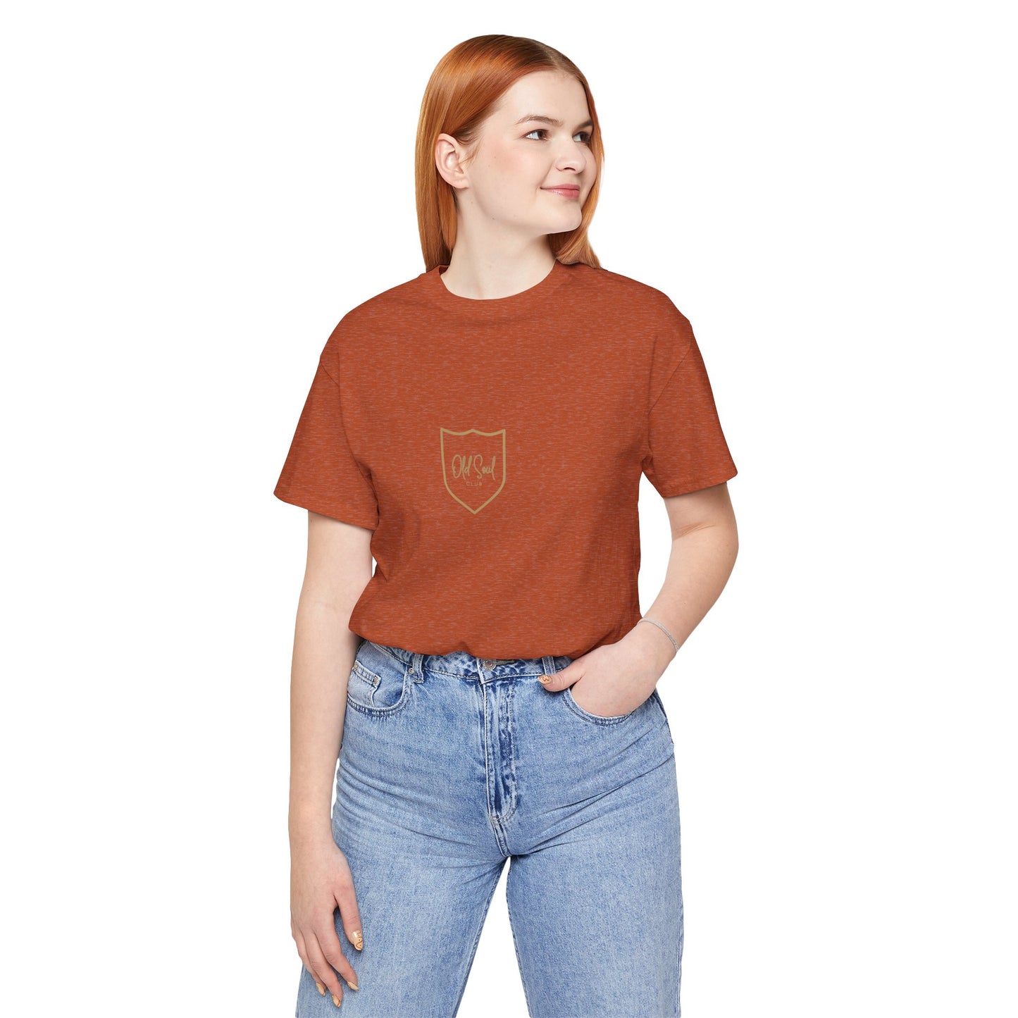 Person wearing a brown t-shirt with a Old Soul logo and blue jeans on a white background