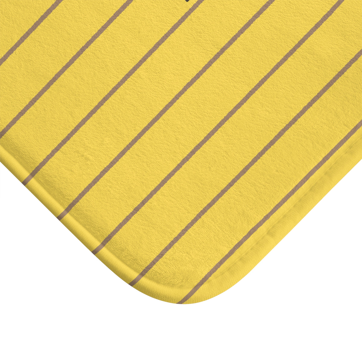 A close-up of a yellow fabric product, likely a bath mat or cushion cover, featuring thin vertical gray stripes and a rounded corner on a white background.