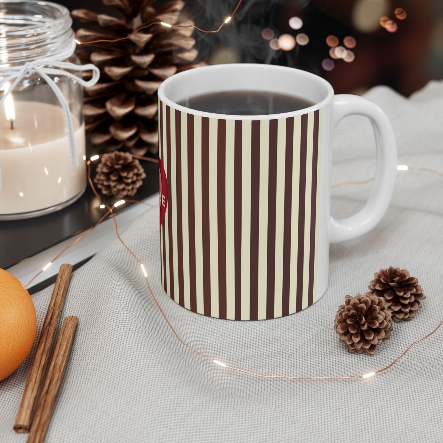 White mug with green pattern on a table with decorative items