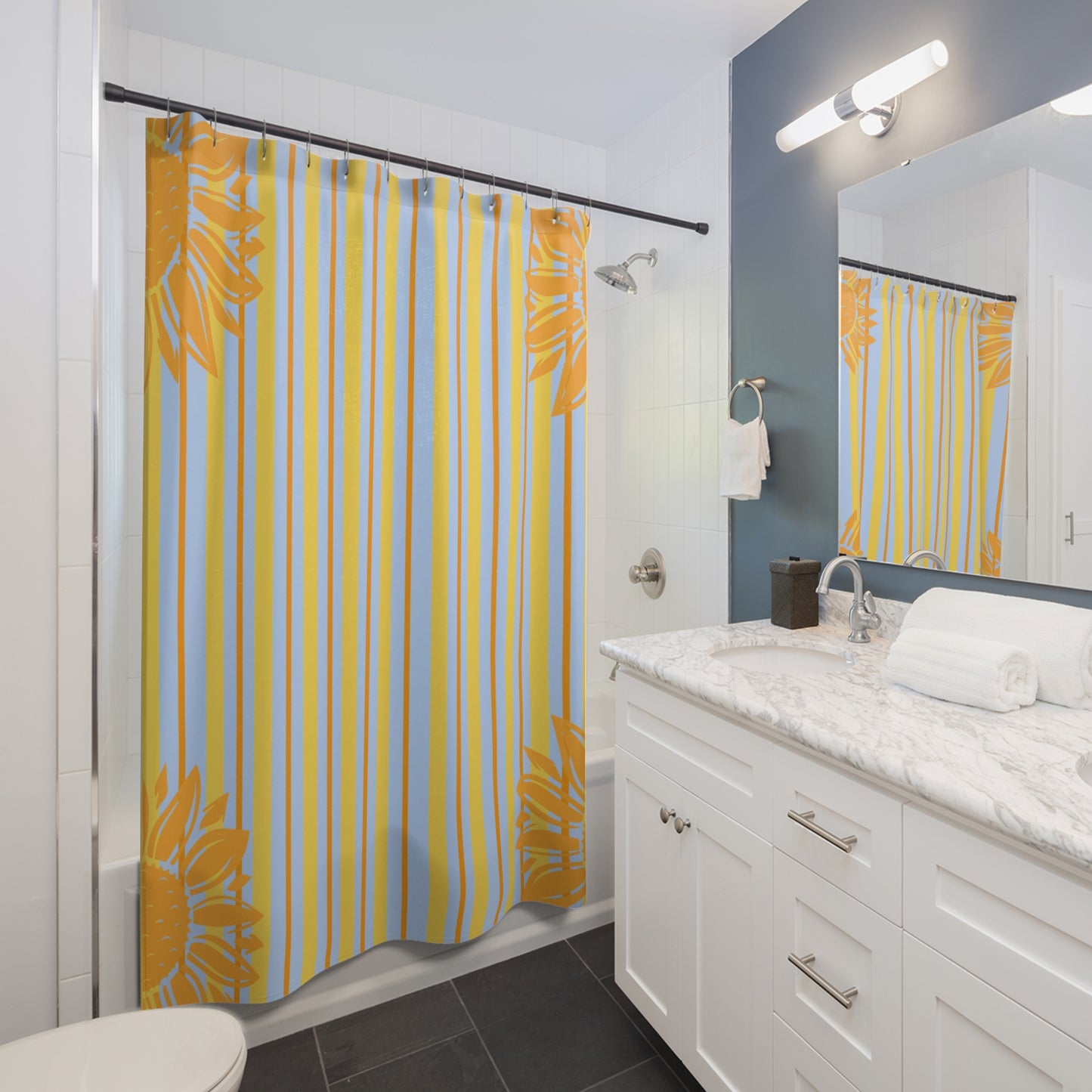 Bathroom with a yellow and blue striped shower curtain, white vanity, and mirror.