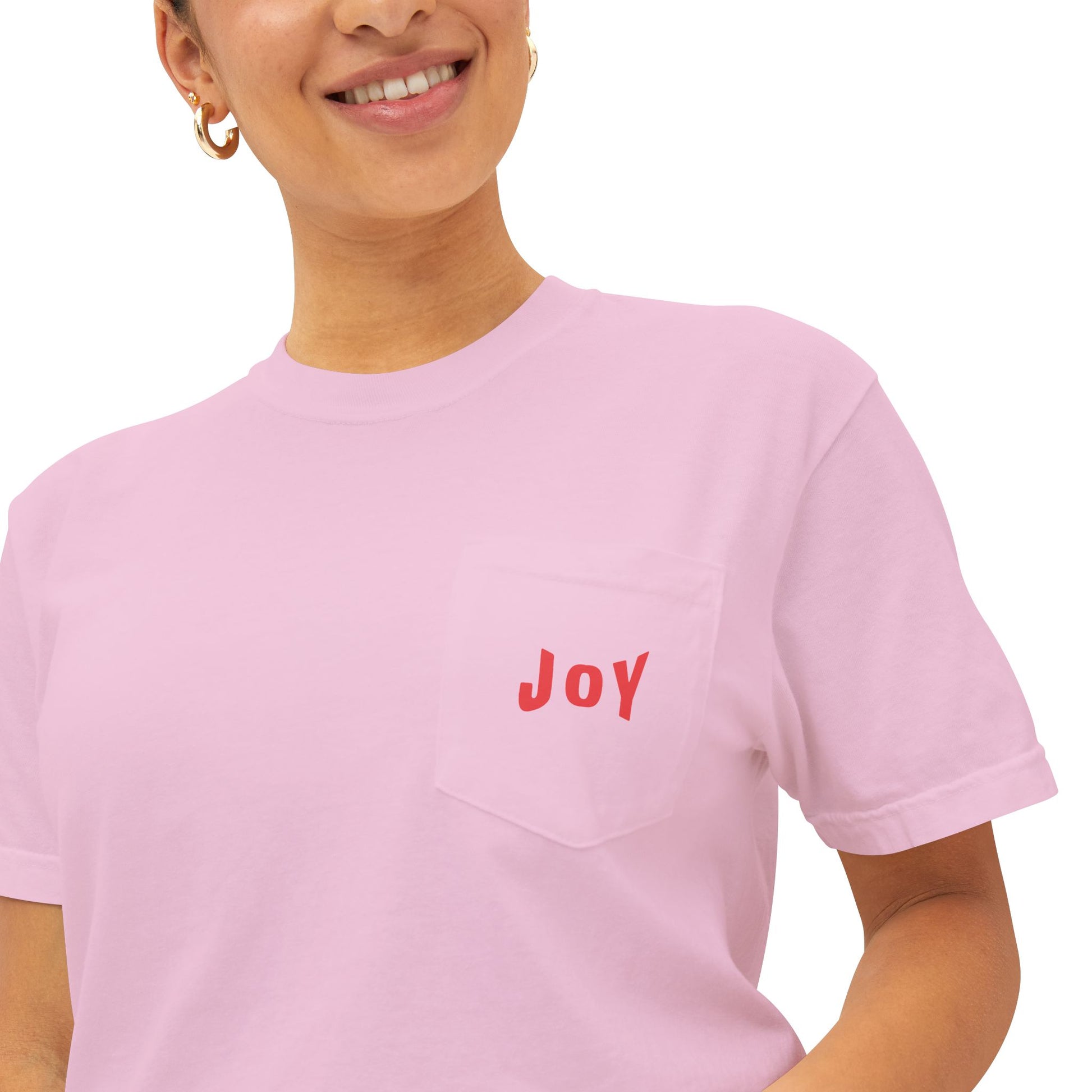 Person wearing a pink t-shirt with 'JOY' printed on it against a white background