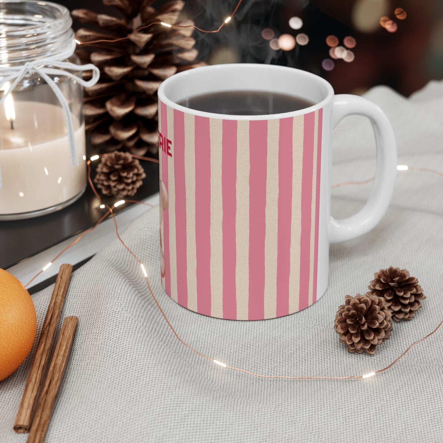 Striped mug with a decorative background featuring a candle, oranges, and pine cones.