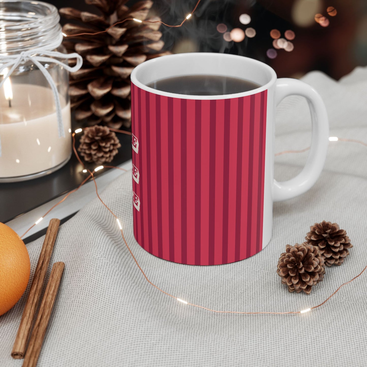 Red striped mug with a white handle on a table with decorative items