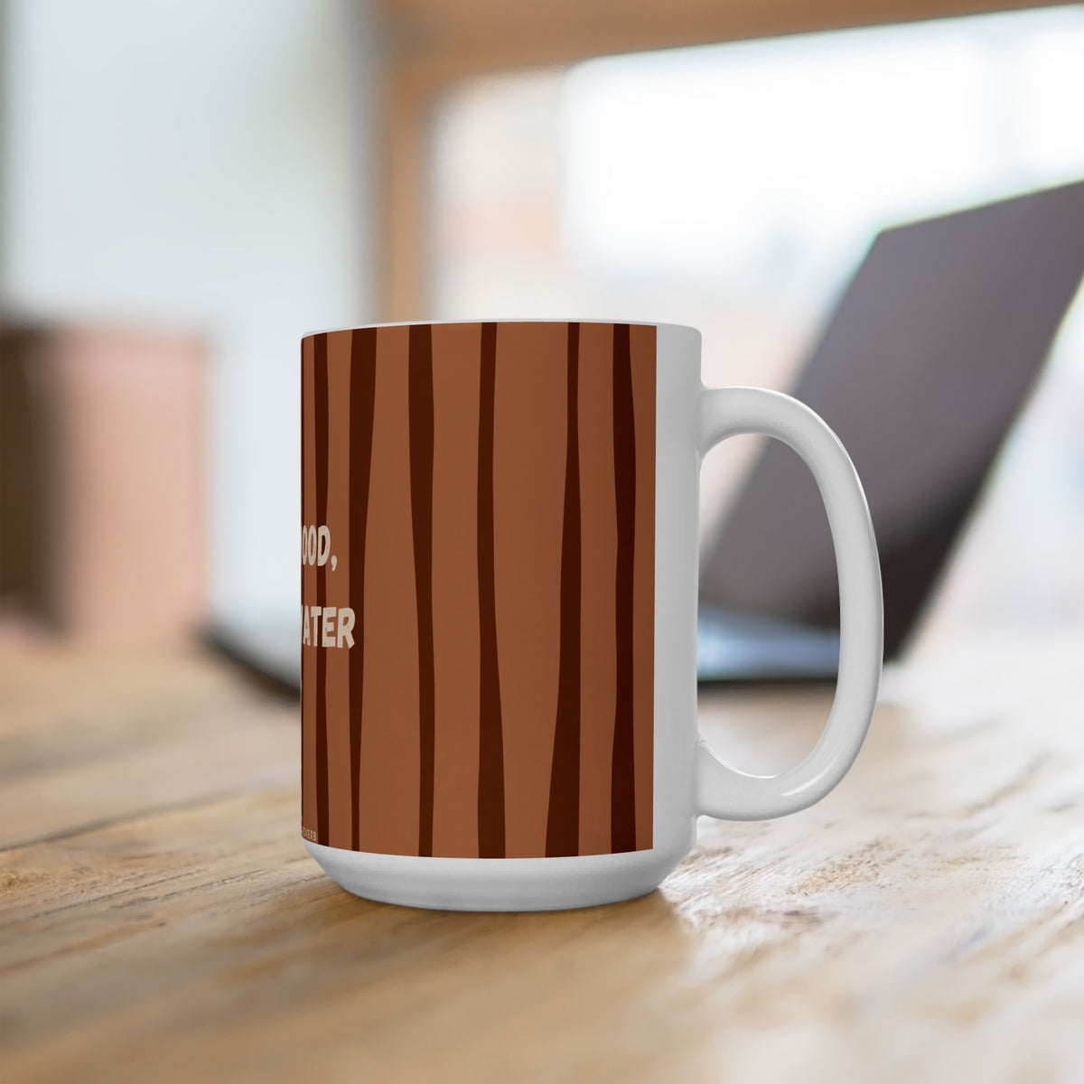 A white ceramic coffee mug with a brown wood-grain pattern, sitting on a wooden table with a blurred laptop in the background.