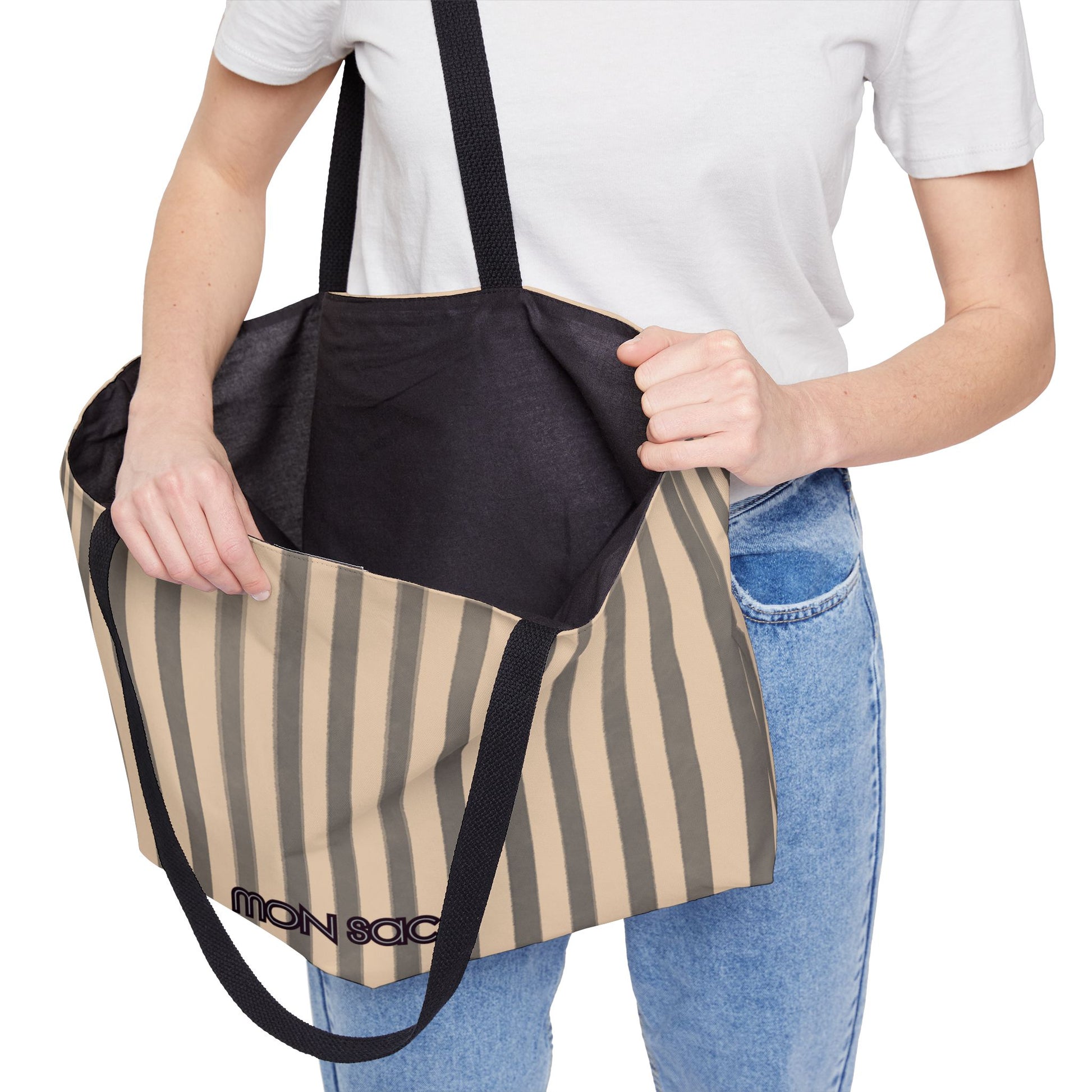 Person holding a striped tote bag with a black interior pocket, brand visible.