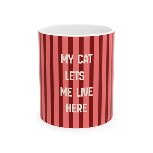 A white ceramic mug with a red and pink vertical striped pattern, featuring the text 'MY CAT LETS ME LIVE HERE' in white capital letters, shown on a plain white background.