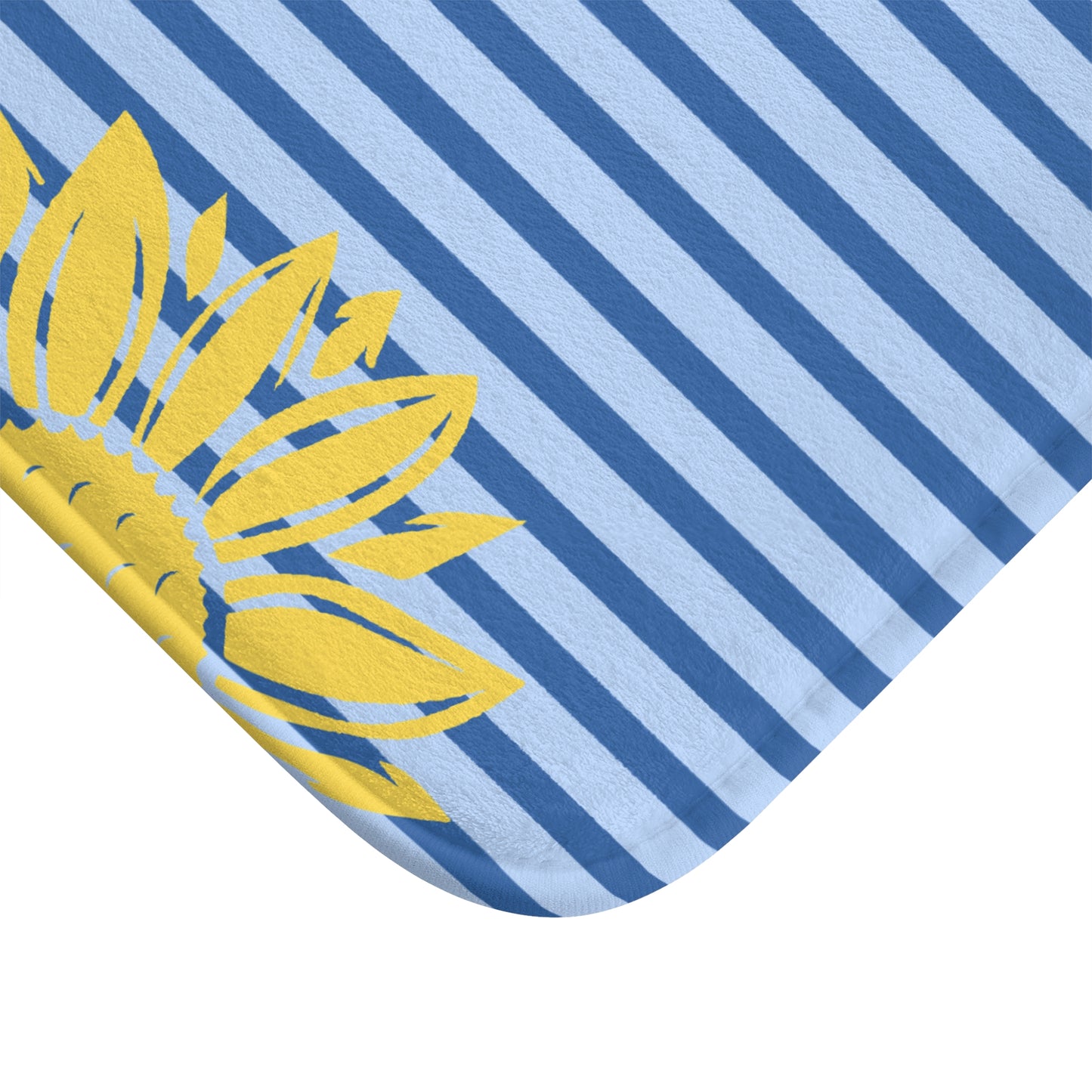 A close-up of a fabric product corner showing a yellow sunflower print over a light blue and dark blue striped background, isolated on a white backdrop.