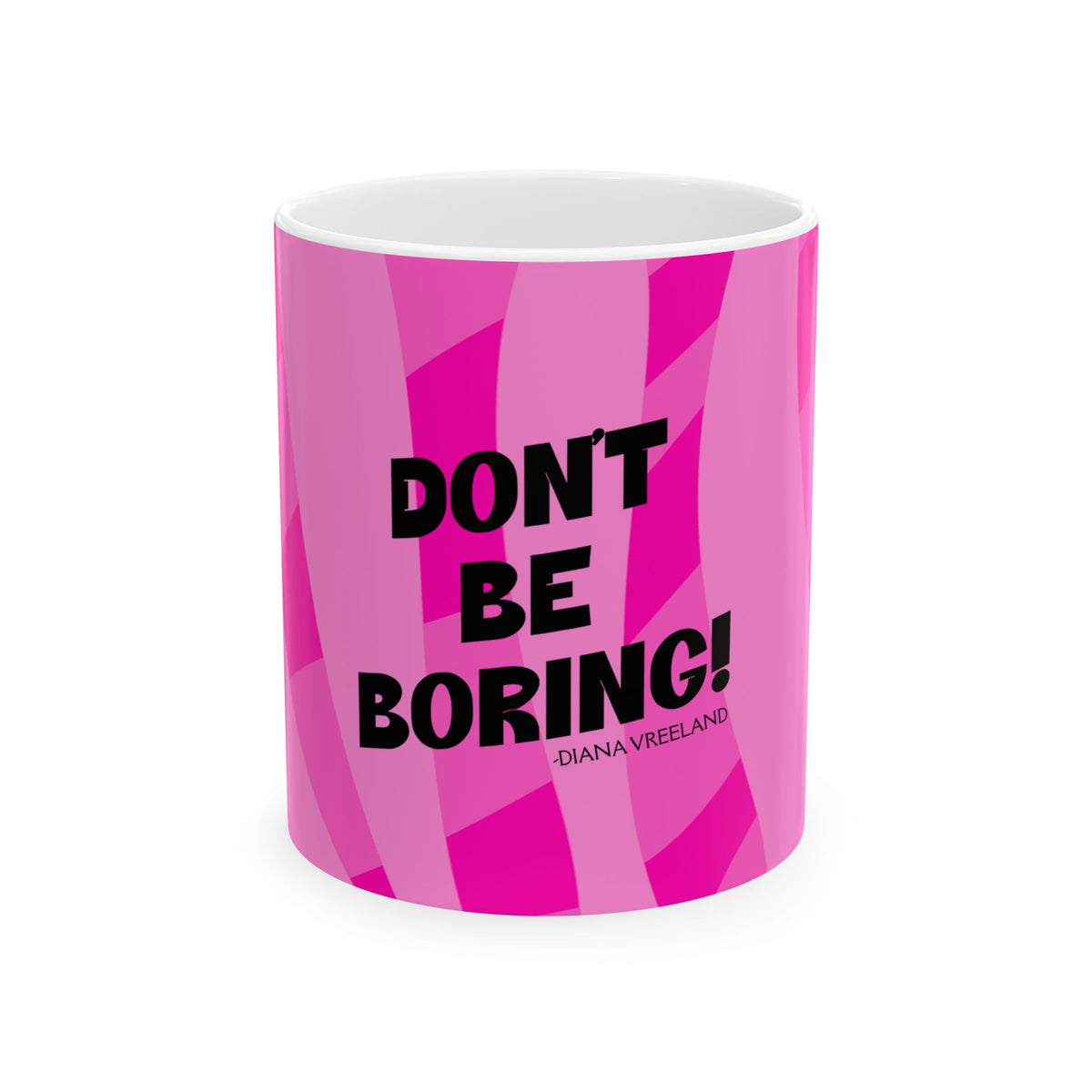 A white ceramic mug with a vibrant pink geometric patterned wrap, featuring the bold black text 'DON'T BE BORING!' and the name '-DIANA VREELAND' printed on the front.