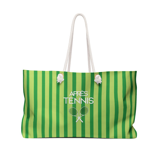 A green and light green vertically striped tote bag with white rope handles and white printed text reading 'APRÈS TENNIS' with a tennis racket graphic, shown on a plain white background.