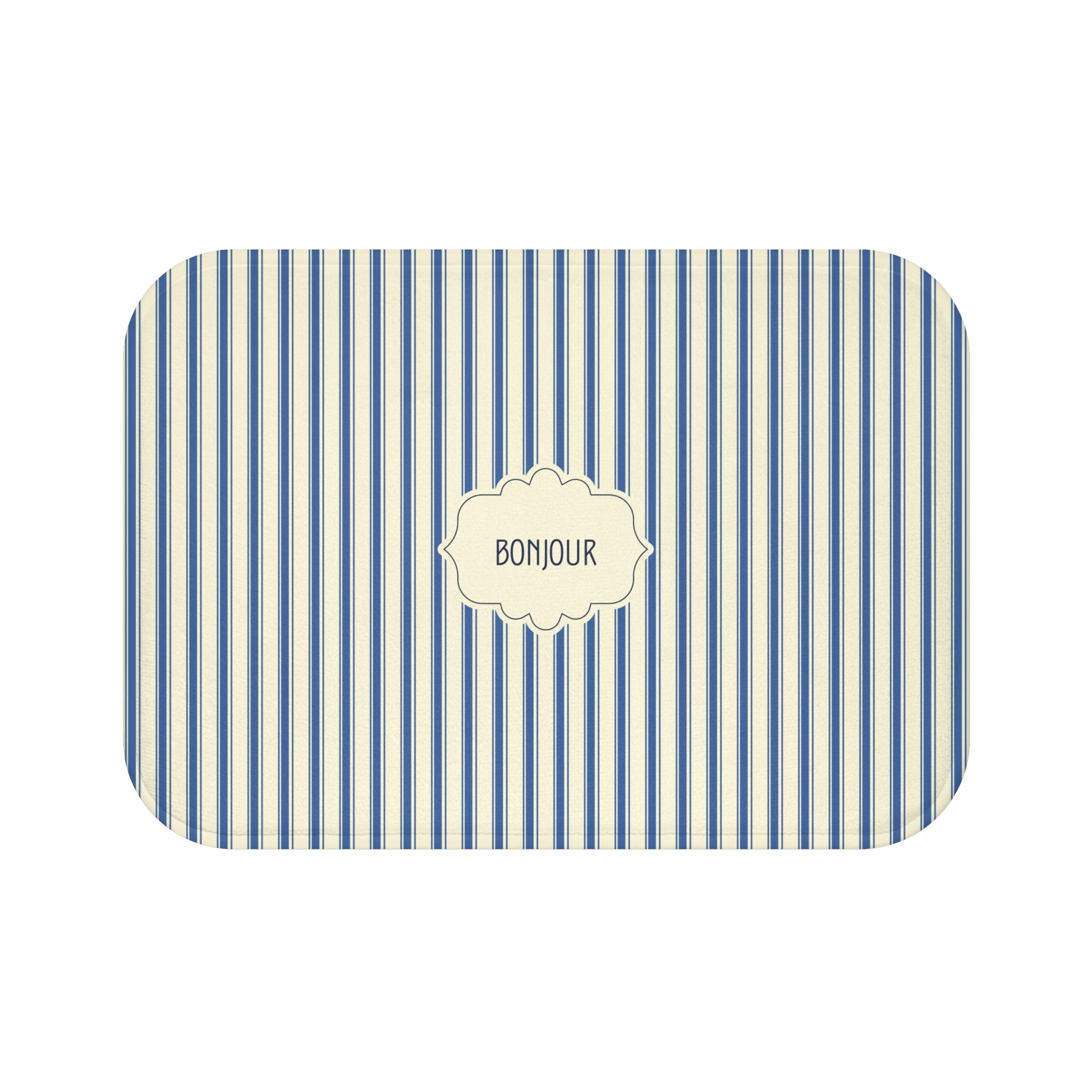 A bath mat with rounded corners, featuring a vertical blue and white stripe pattern and a central cream-colored label that reads 'BONJOUR'.