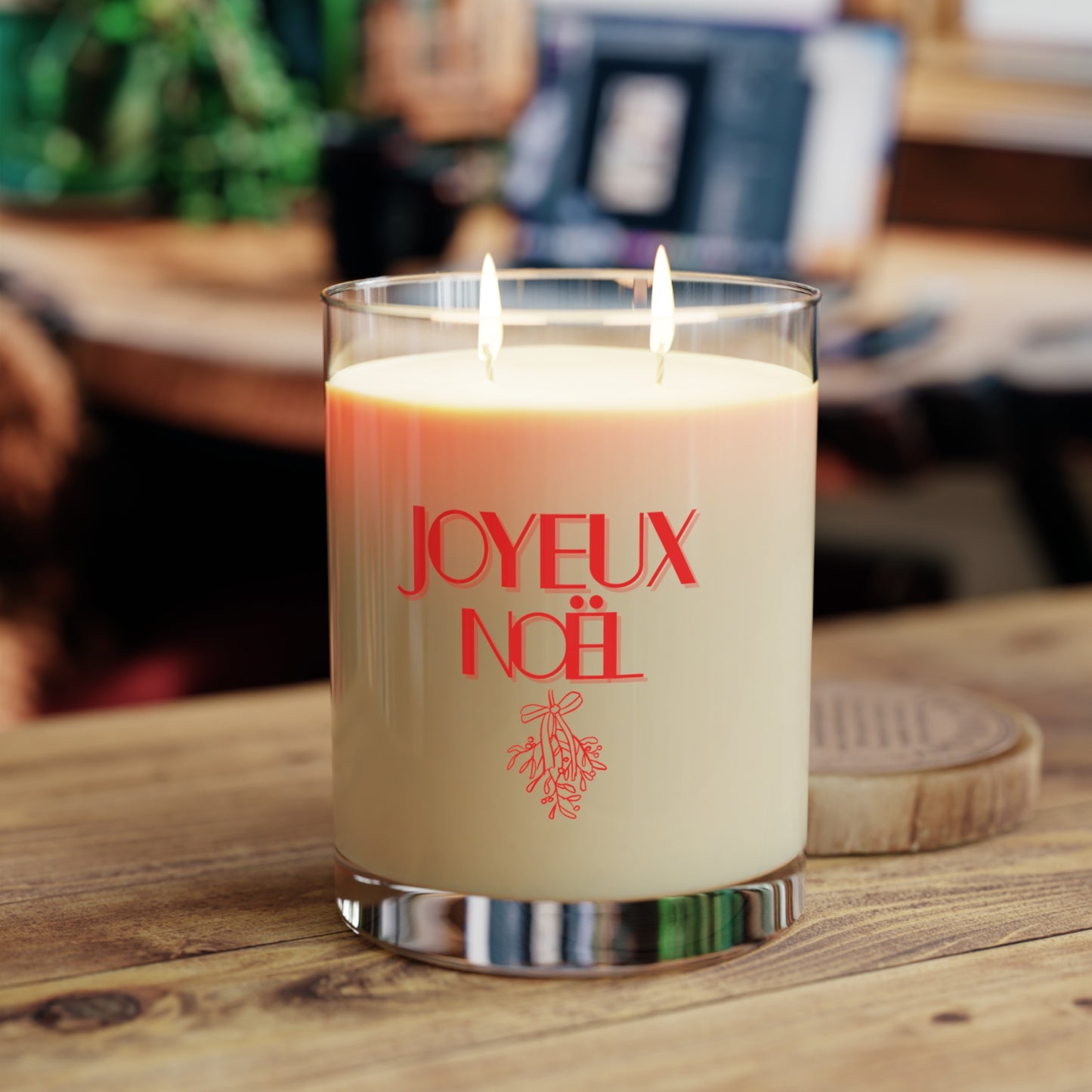 Candle with 'JOYEUX NOEL' text on a wooden surface