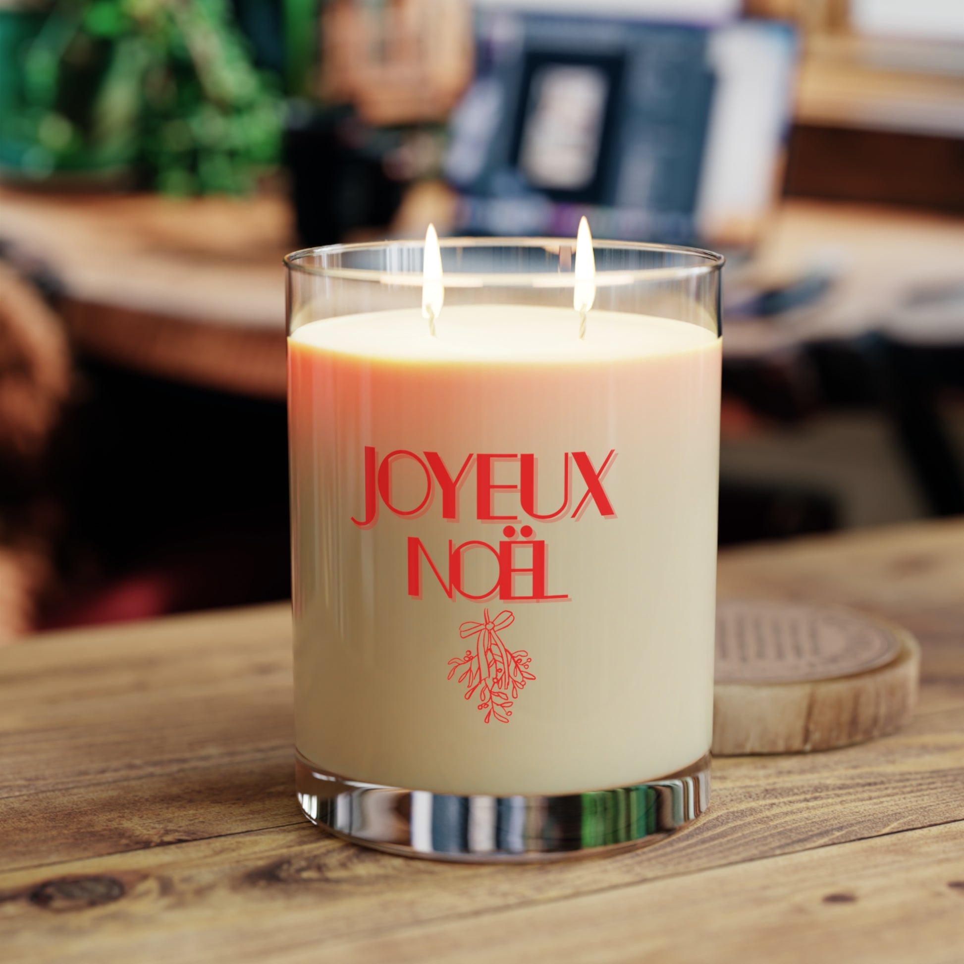 Candle with 'JOYEUX NOEL' text on a wooden surface