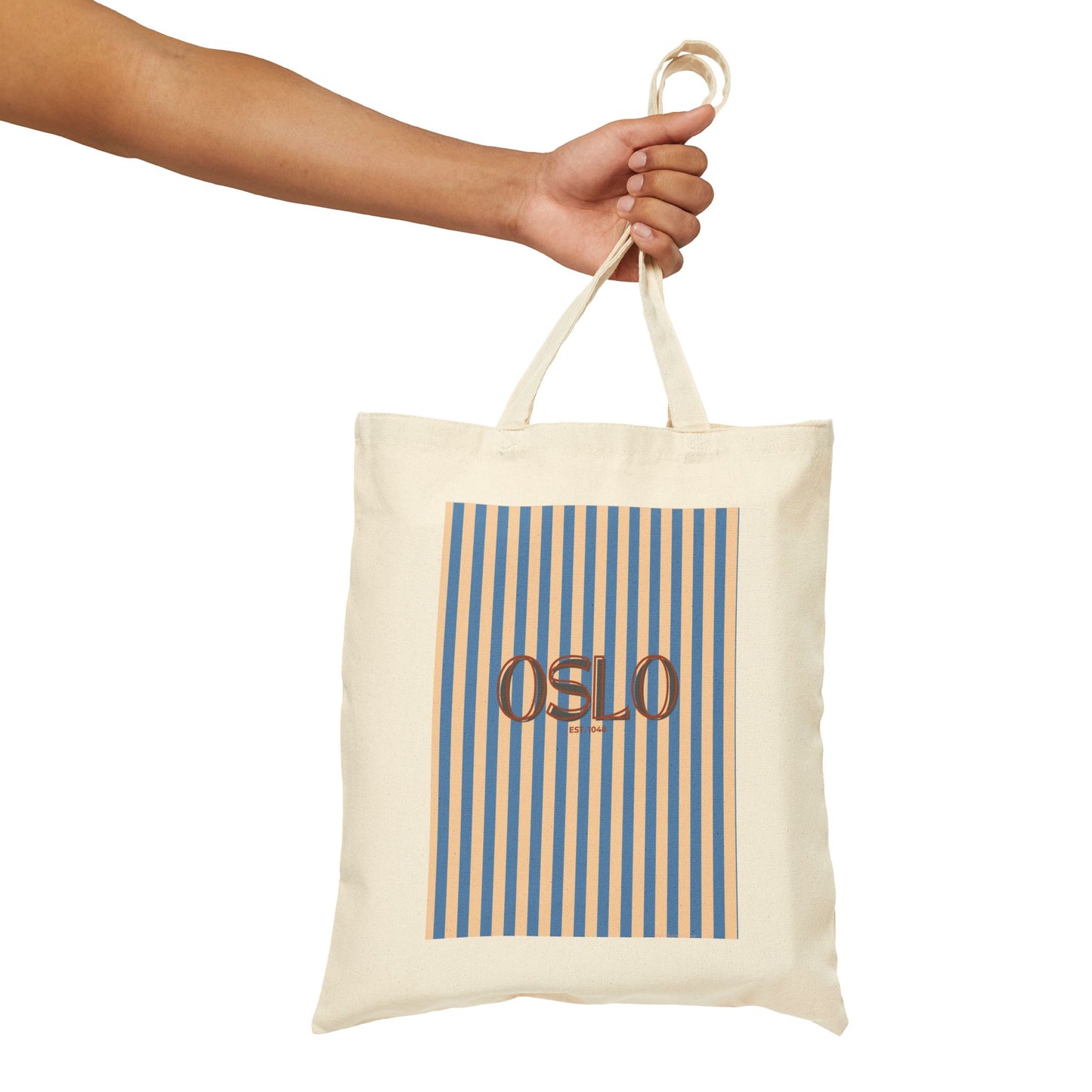 Tote bag with 'OSLO' text and blue stripes held by a hand on a white background