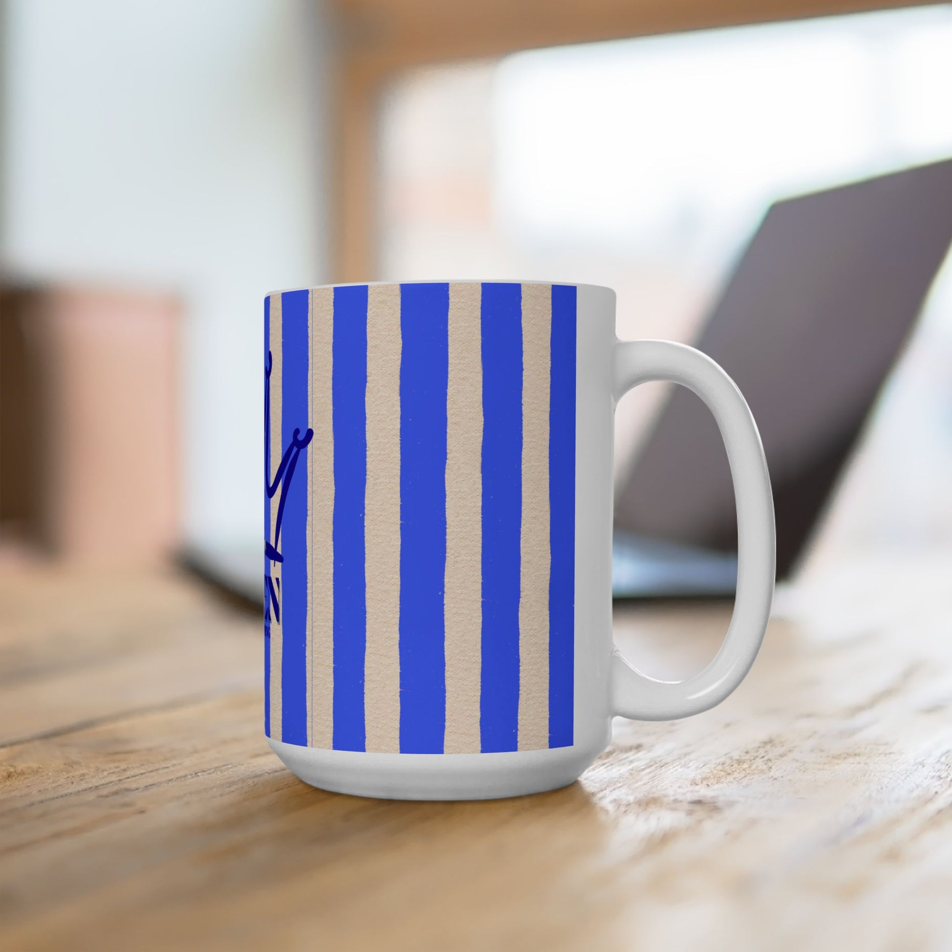White mug with blue and beige striped pattern on a wooden surface