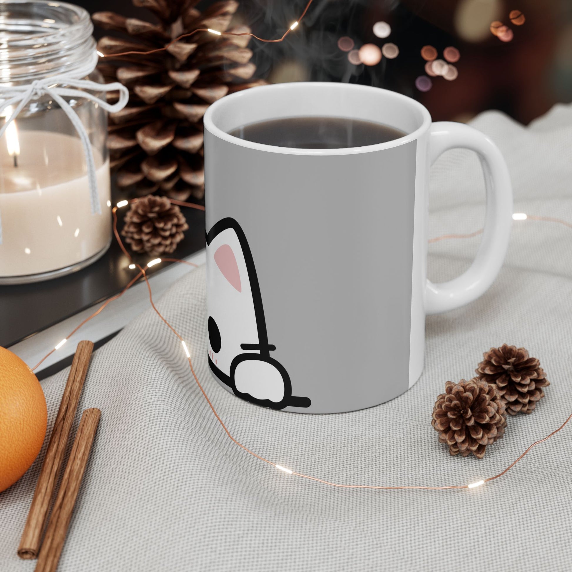 White mug with a cartoon bunny design on a table with decorative items