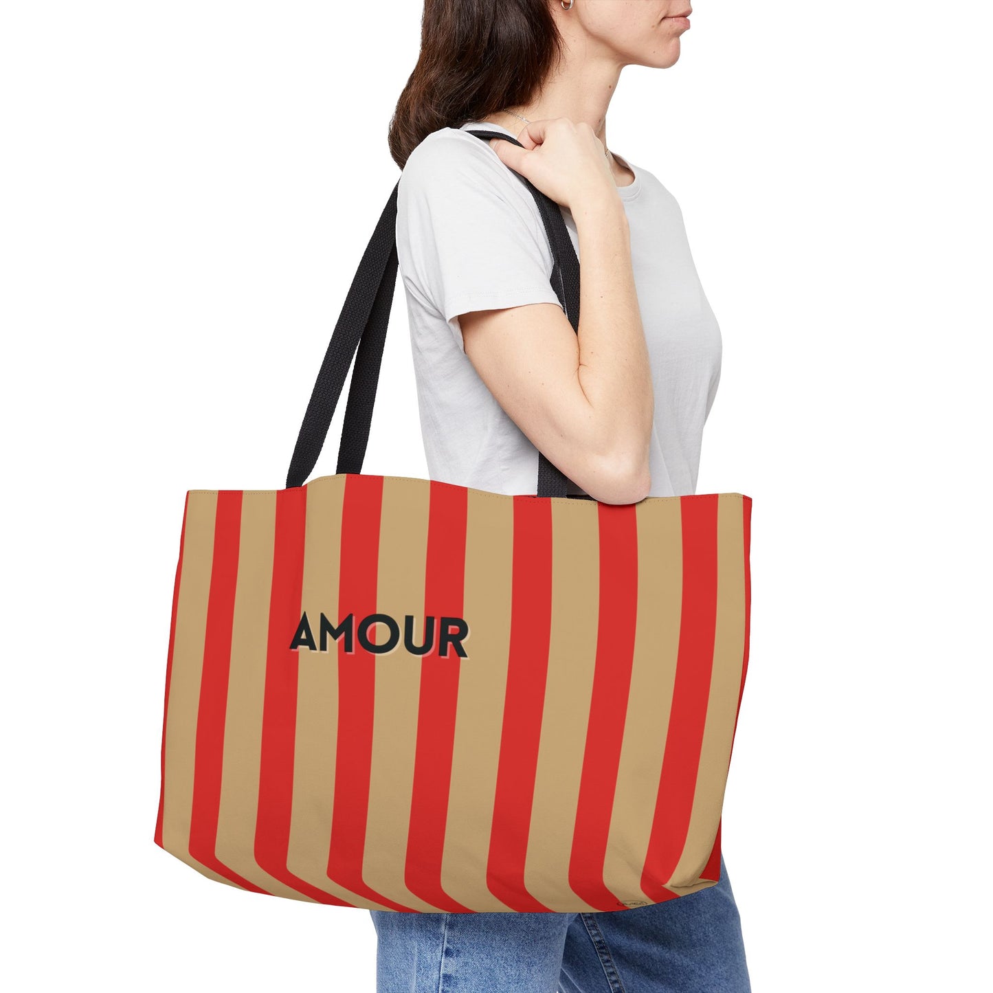 Person holding a red and beige striped tote bag with 'AMOUR' text.