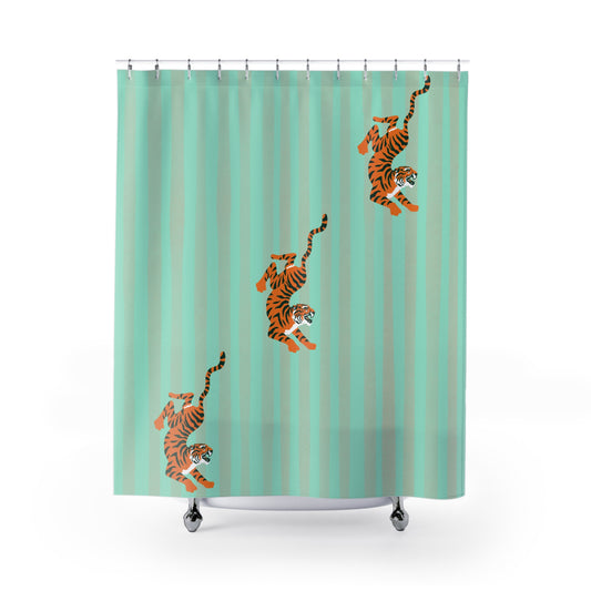 A mint green shower curtain with vertical stripes and three orange and black tiger illustrations, shown hanging from silver hooks on a white background.