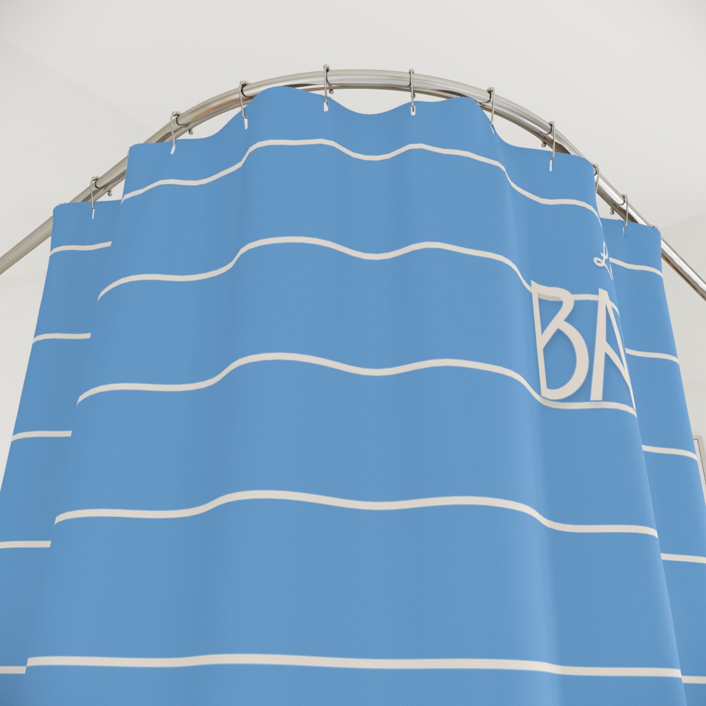 Blue shower curtain with white stripes and 'Bath' text on a metal rod.