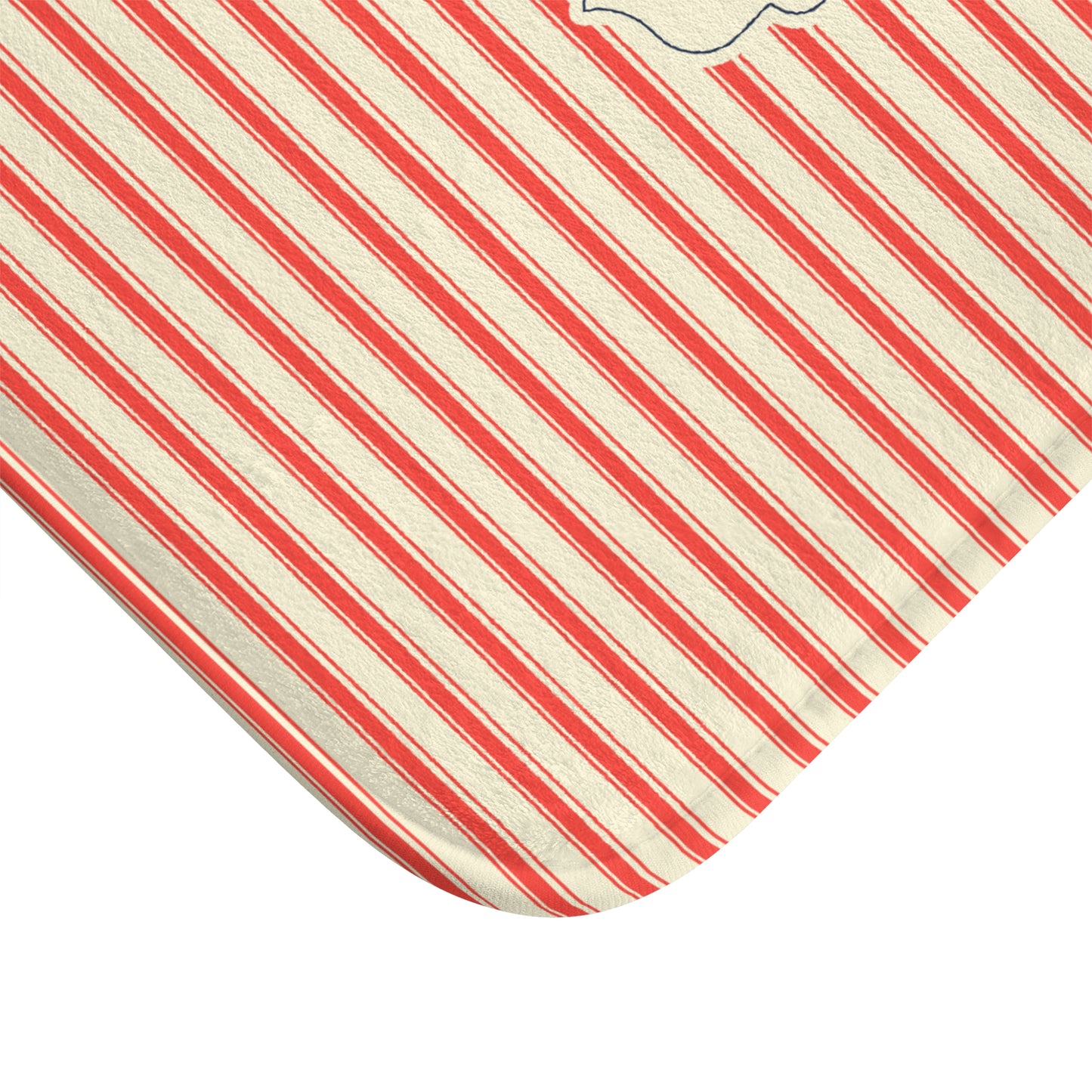 A close-up of a corner of a baby blanket or mattress cover featuring diagonal red and off-white stripes on a white background.