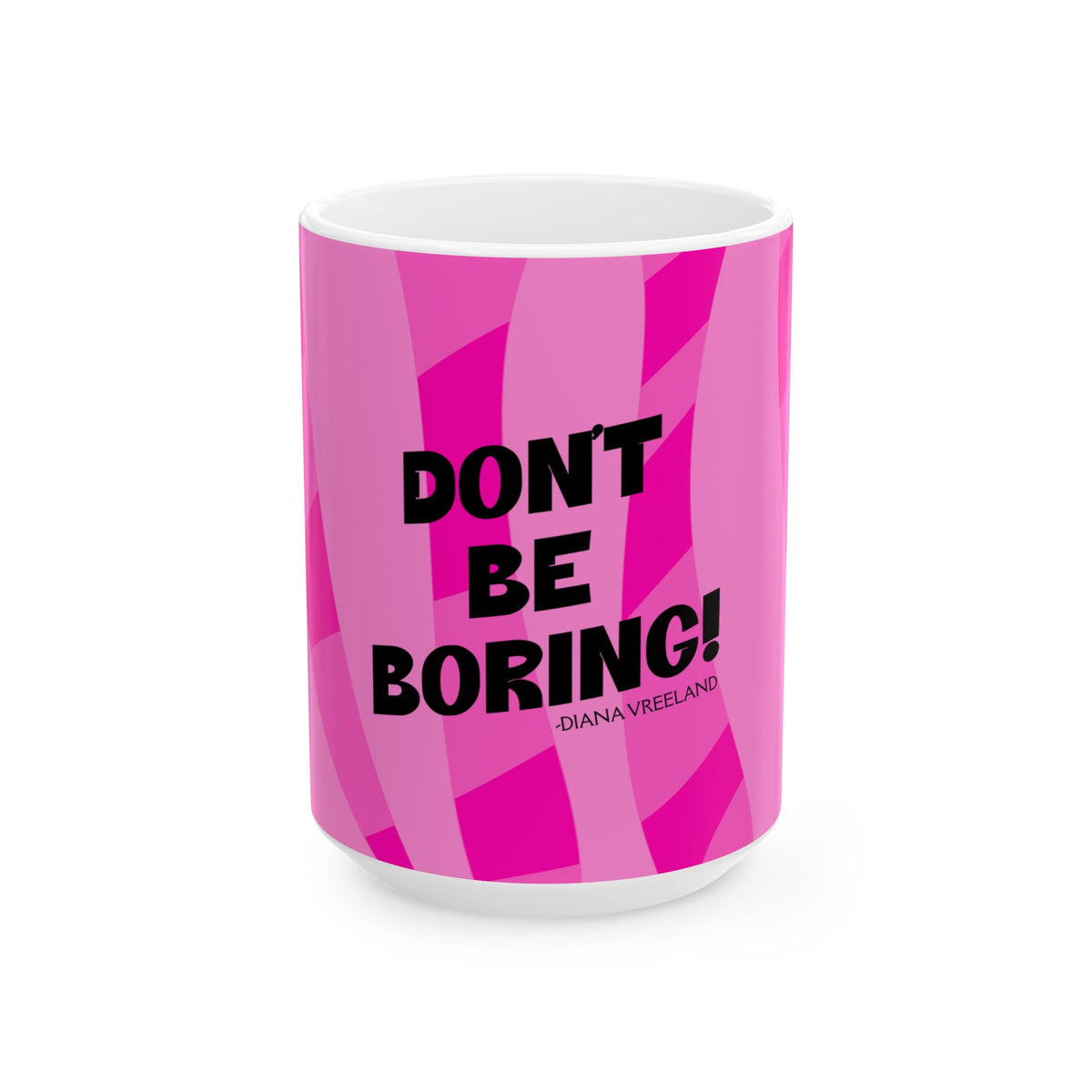 A white ceramic mug featuring a vibrant pink geometric patterned wrap with the text 'DON'T BE BORING!' in bold black letters and the name 'DIANA VREELAND' printed below in smaller black text.