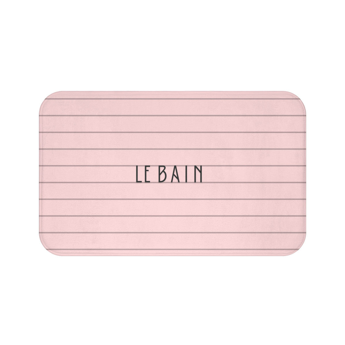 A rectangular bath mat with rounded corners, featuring a light pink background with thin dark horizontal lines and the text 'LE BAIN' printed in the center.
