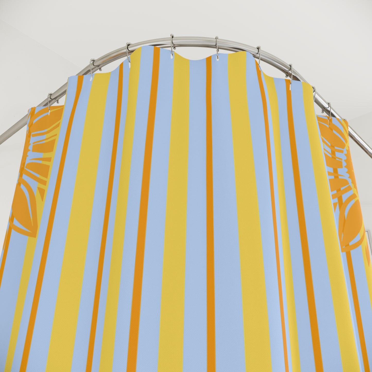 Striped yellow and blue shower curtain on a silver rod against a white background