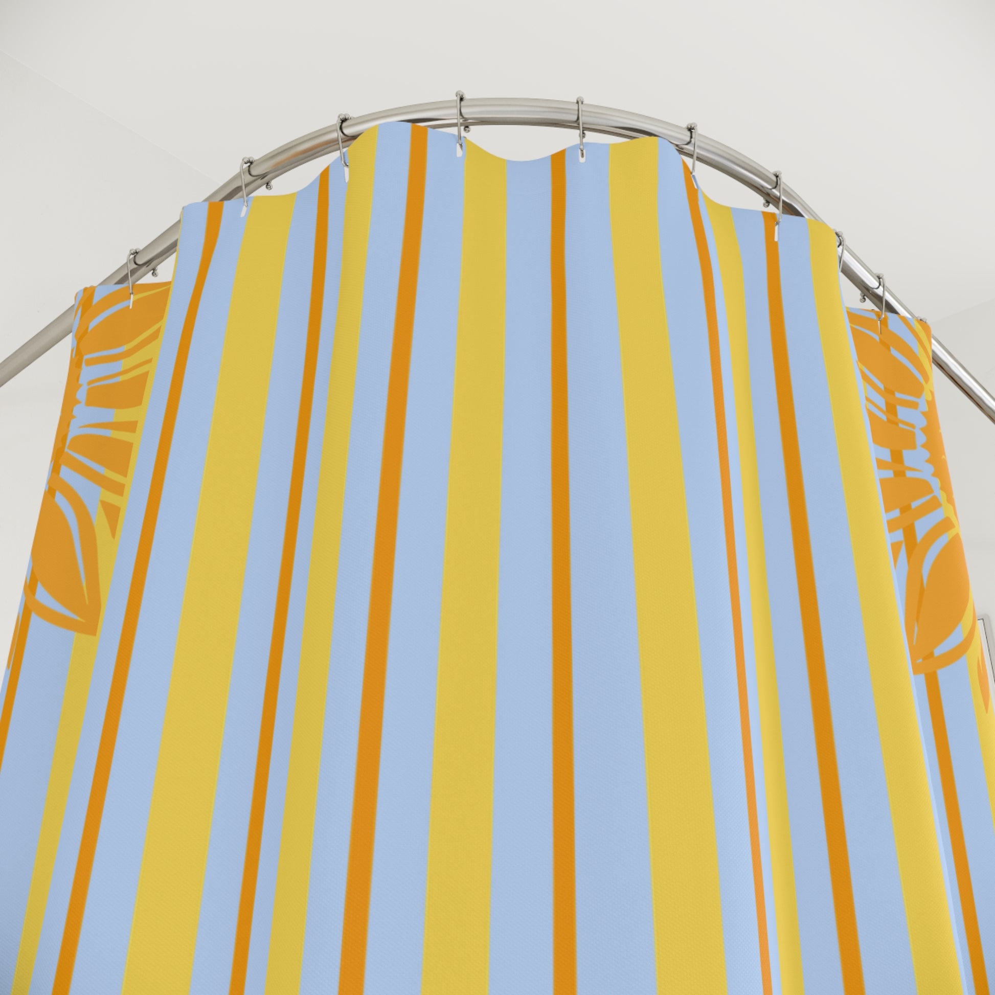 Striped yellow and blue shower curtain on a silver rod against a white background