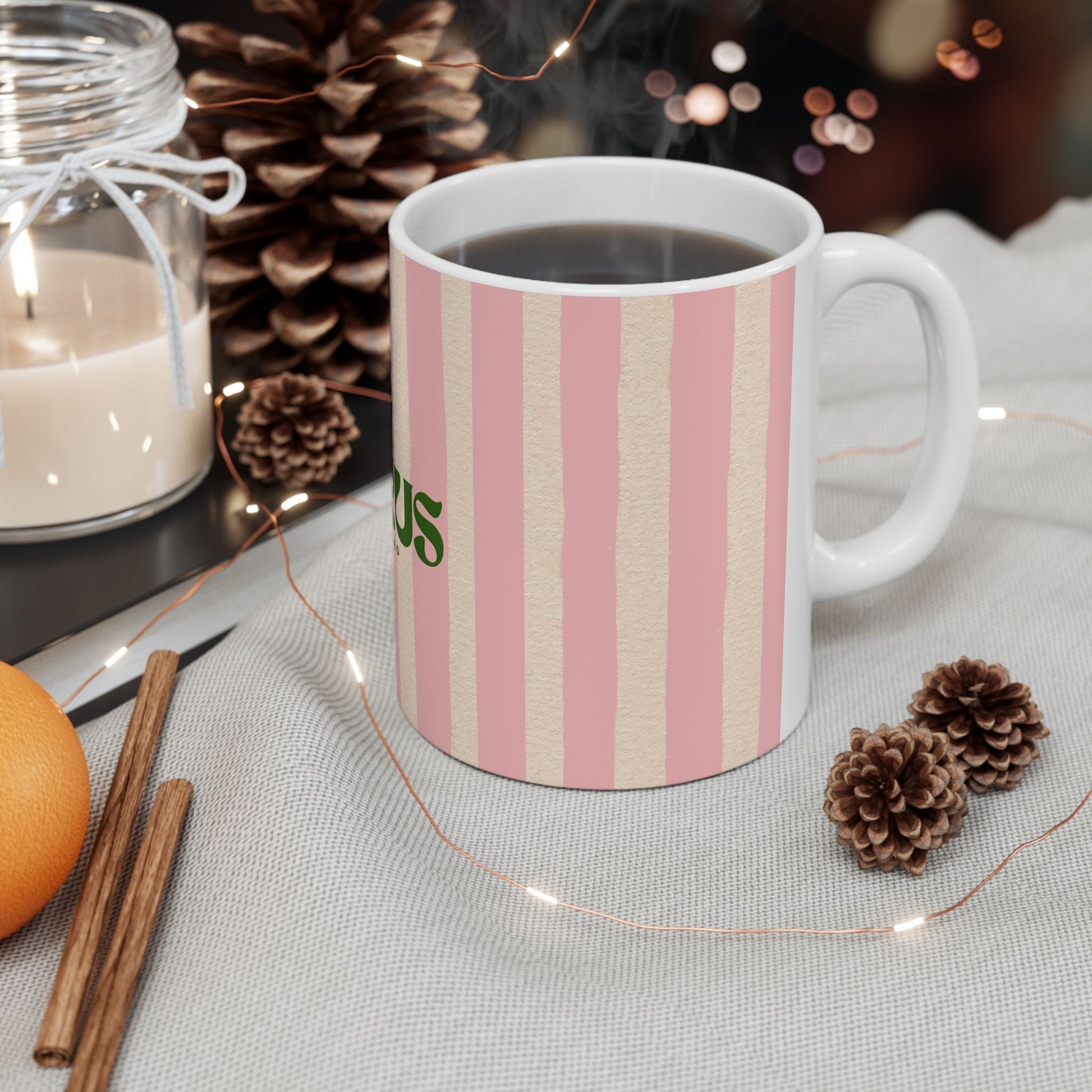 Striped mug with a brand logo on a table with decorative items