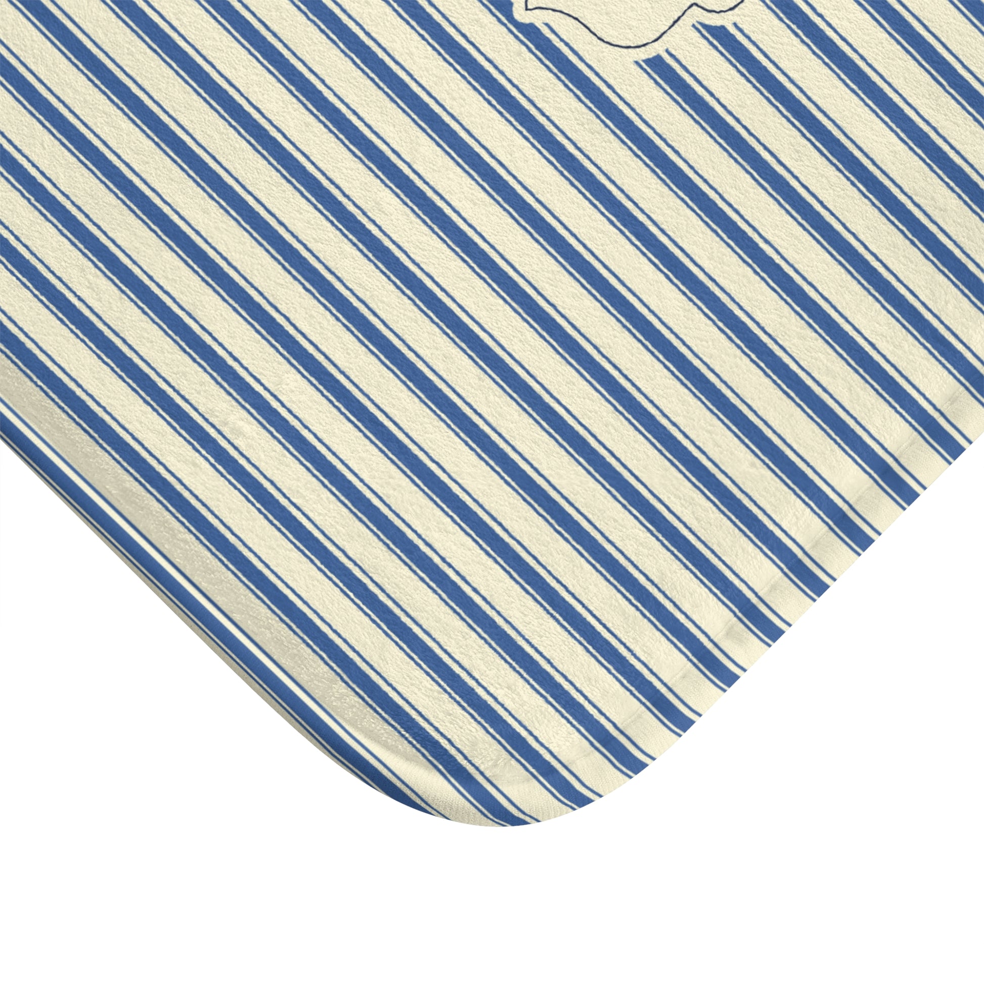 A close-up of a corner of a striped fabric item, showing diagonal blue and off-white stripes with a small embroidered monogram near the top edge, photographed on a white background.