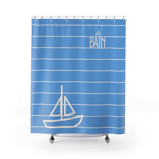 Blue shower curtain with white stripes and sailboat design on a white background