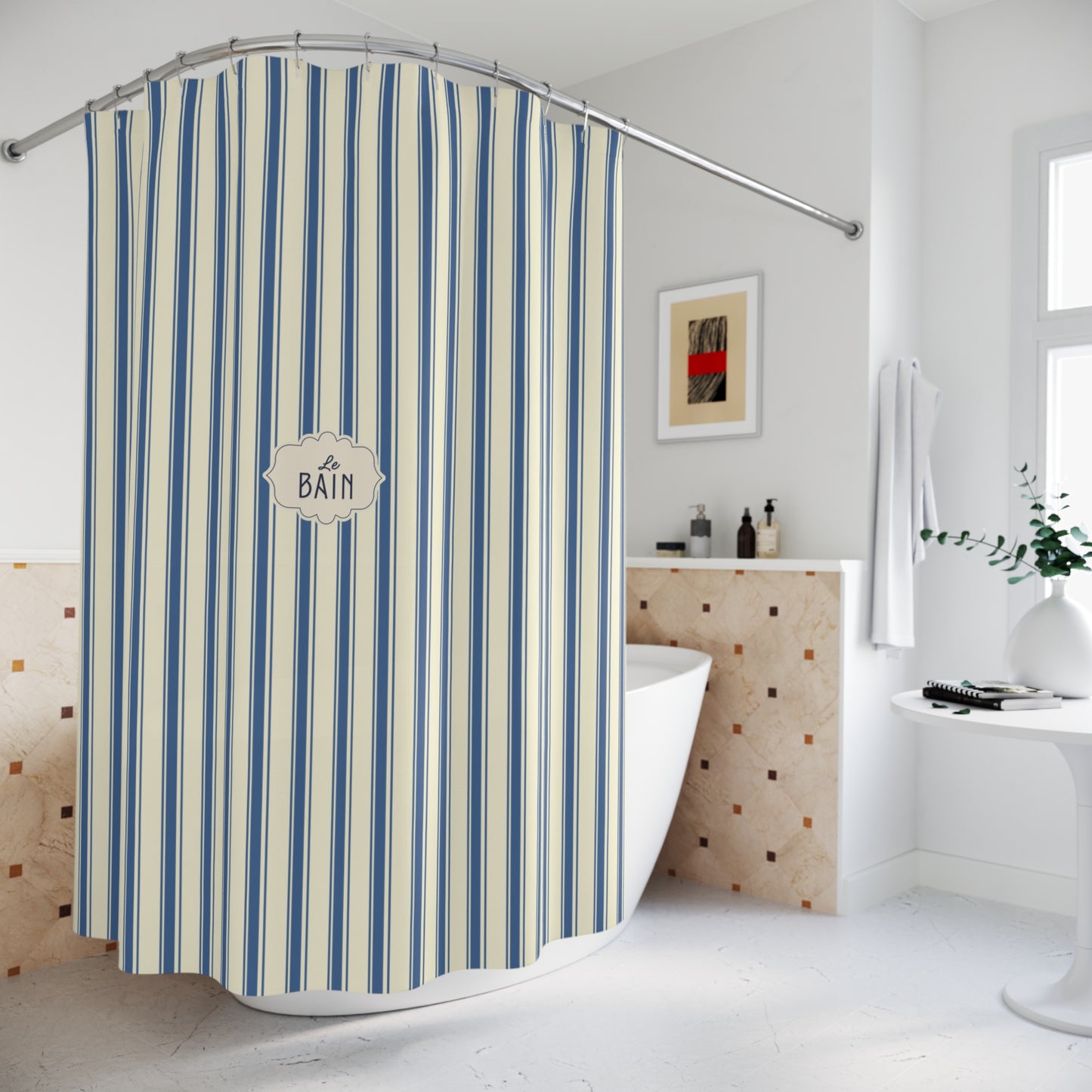 A blue and cream striped shower curtain hanging in a bright, modern bathroom. The curtain features vertical stripes in shades of blue, navy, and cream, with a central decorative label that reads 'A BATH'.