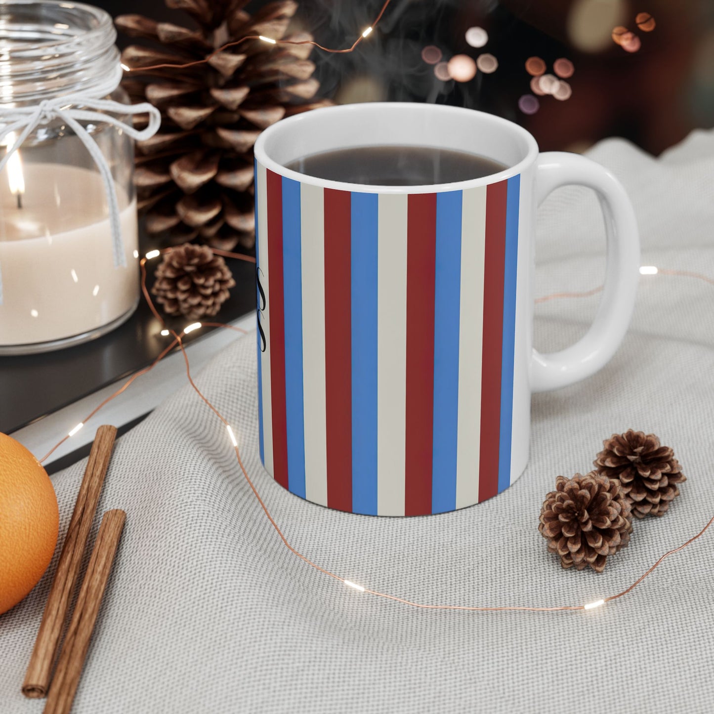 White mug with purple and black pattern on a table with decorative items