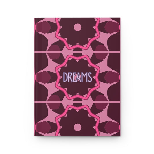 Notebook with pink and purple geometric pattern and 'DREAMS' text on a white background