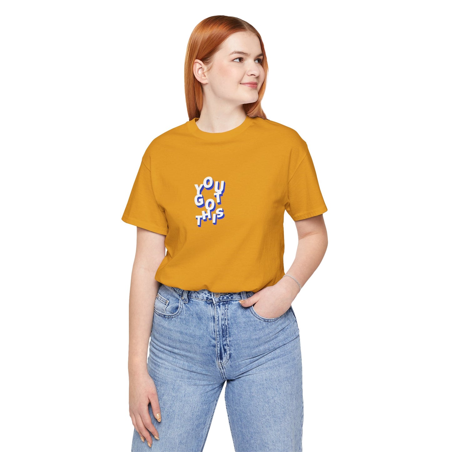 Person wearing a mustard yellow t-shirt with text and blue jeans on a white background