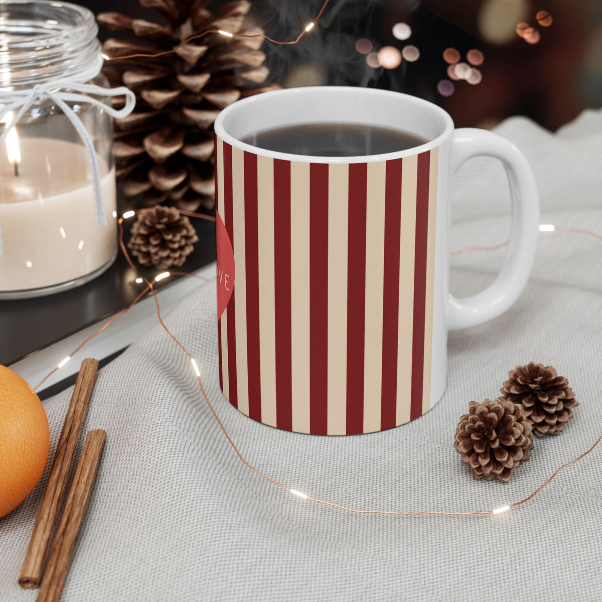 White mug with red floral pattern on a table with decorative items