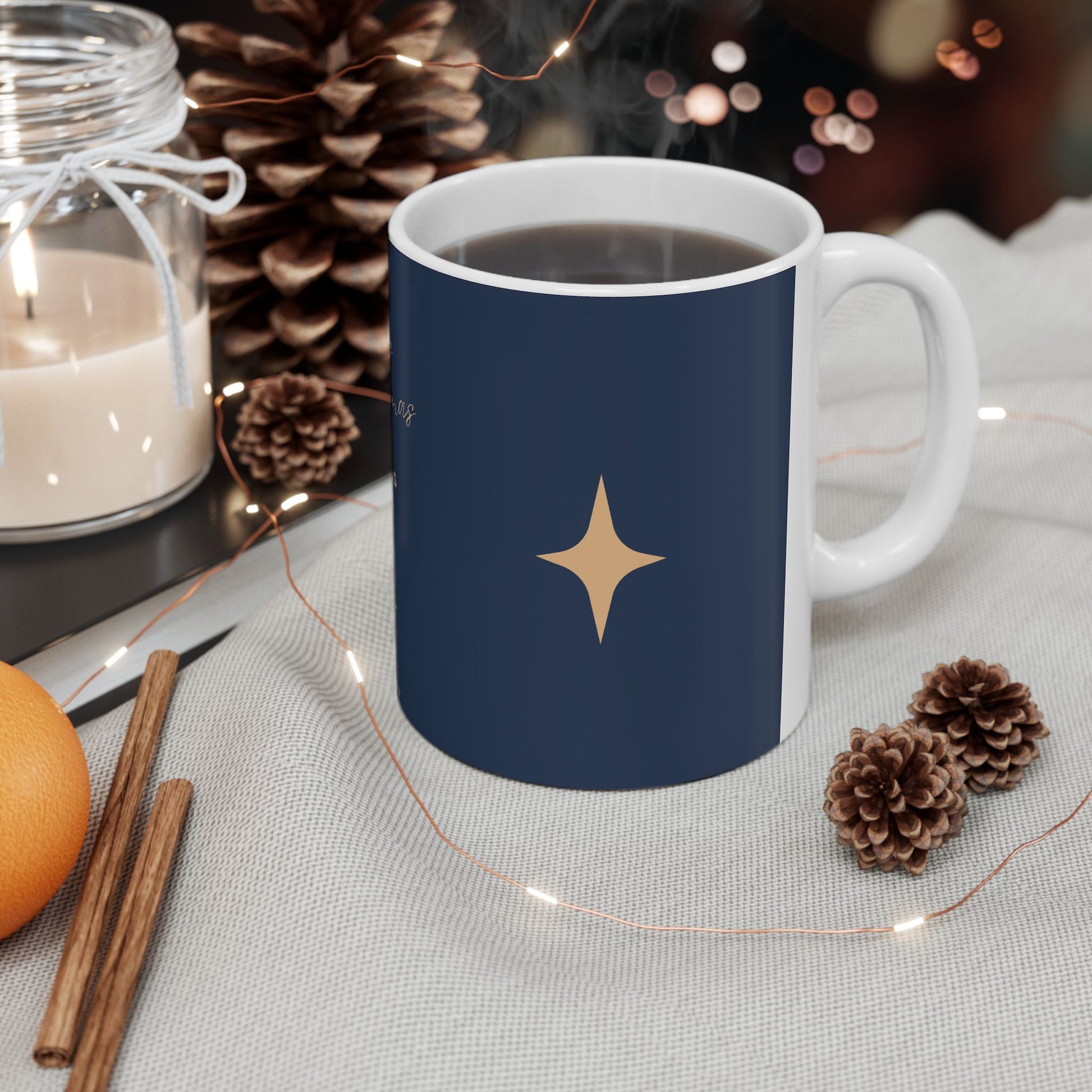 Navy blue mug with a gold star design on a table with decorative items.