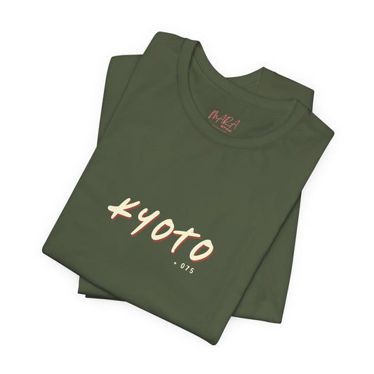 Folded green t-shirt with 'Kyoto 075' print on a white background