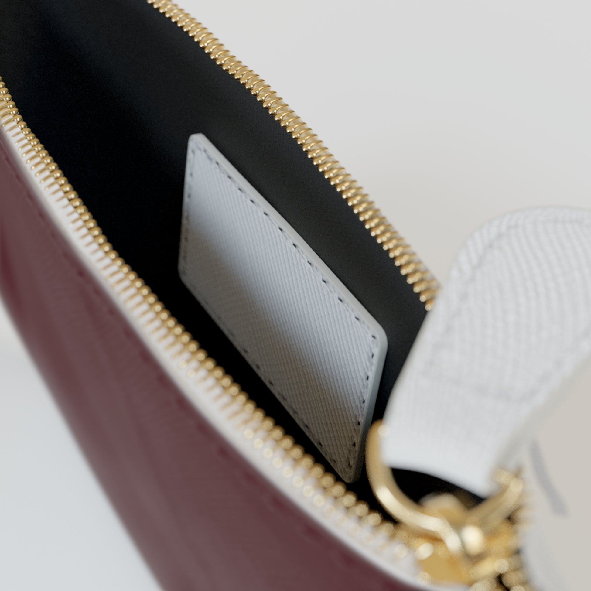 Close-up of a handbag with gold zipper and white interior