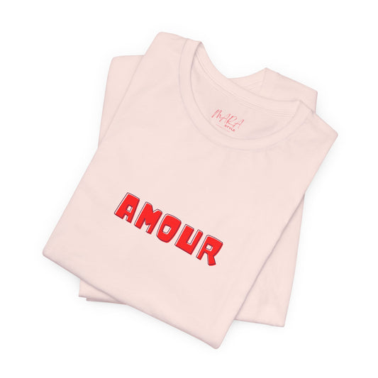 Folded pink tshirt with 'AMOUR' printed in red on a white background