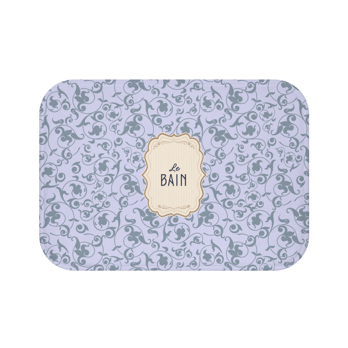 A rectangular bath mat with rounded corners, featuring a light lavender background with a repeating gray damask pattern and a central cream-colored decorative label that reads 'Le Bain'.