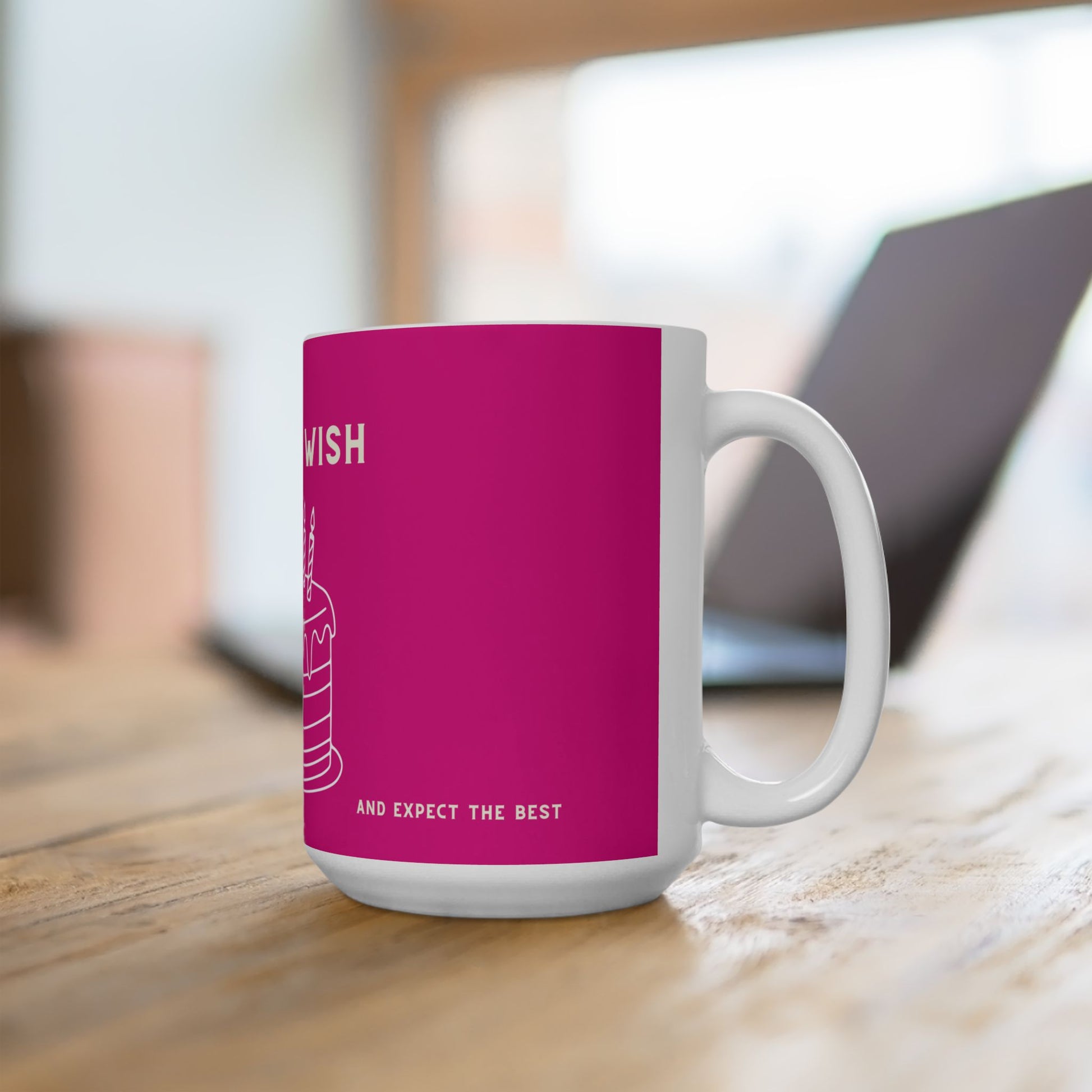 White mug with a pink sleeve featuring text on a wooden surface.