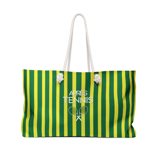 A green and yellow vertically striped tote bag with white rope handles and a white 'APRES TENNIS' graphic featuring tennis rackets on the front, set against a plain white background.