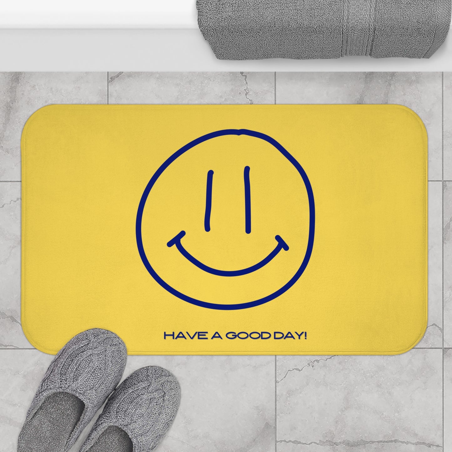 Yellow mat with blue smiley face and 'Have a Good Day!' text on a marble floor.