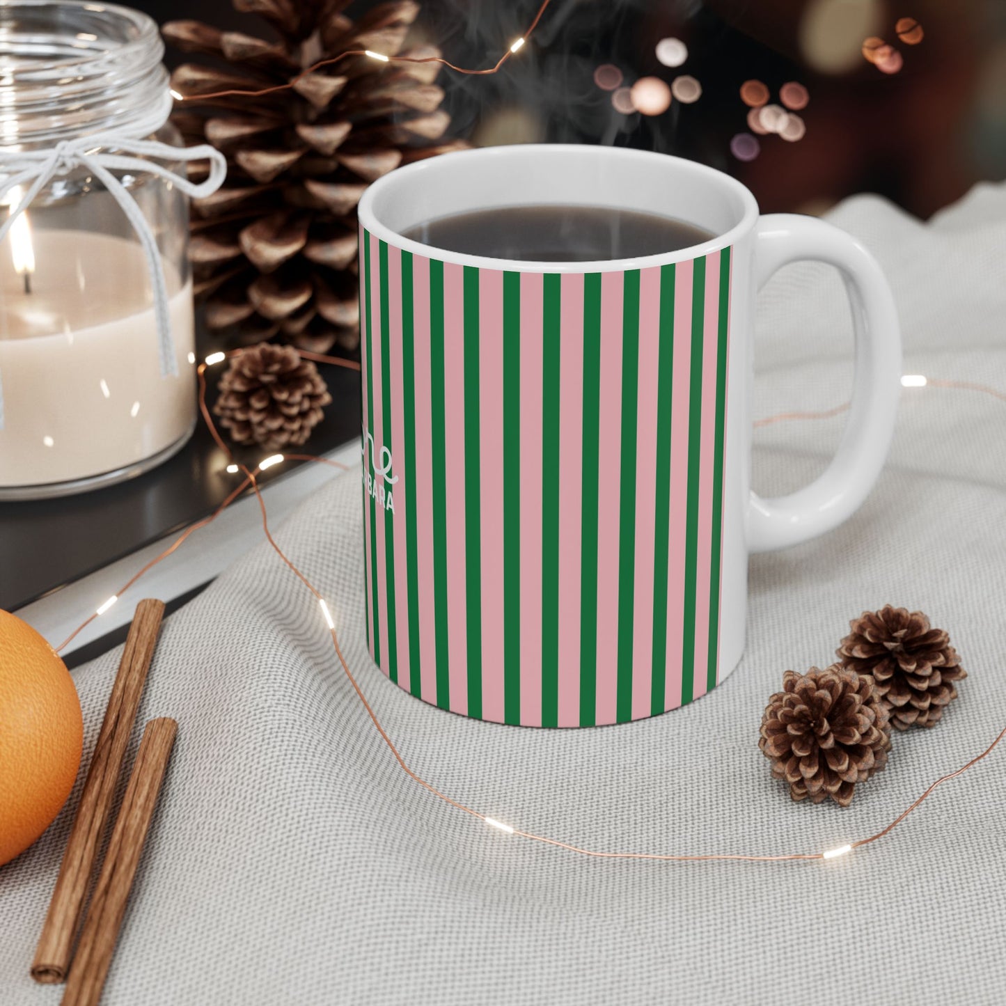 White mug with green pattern on a table with decorative items