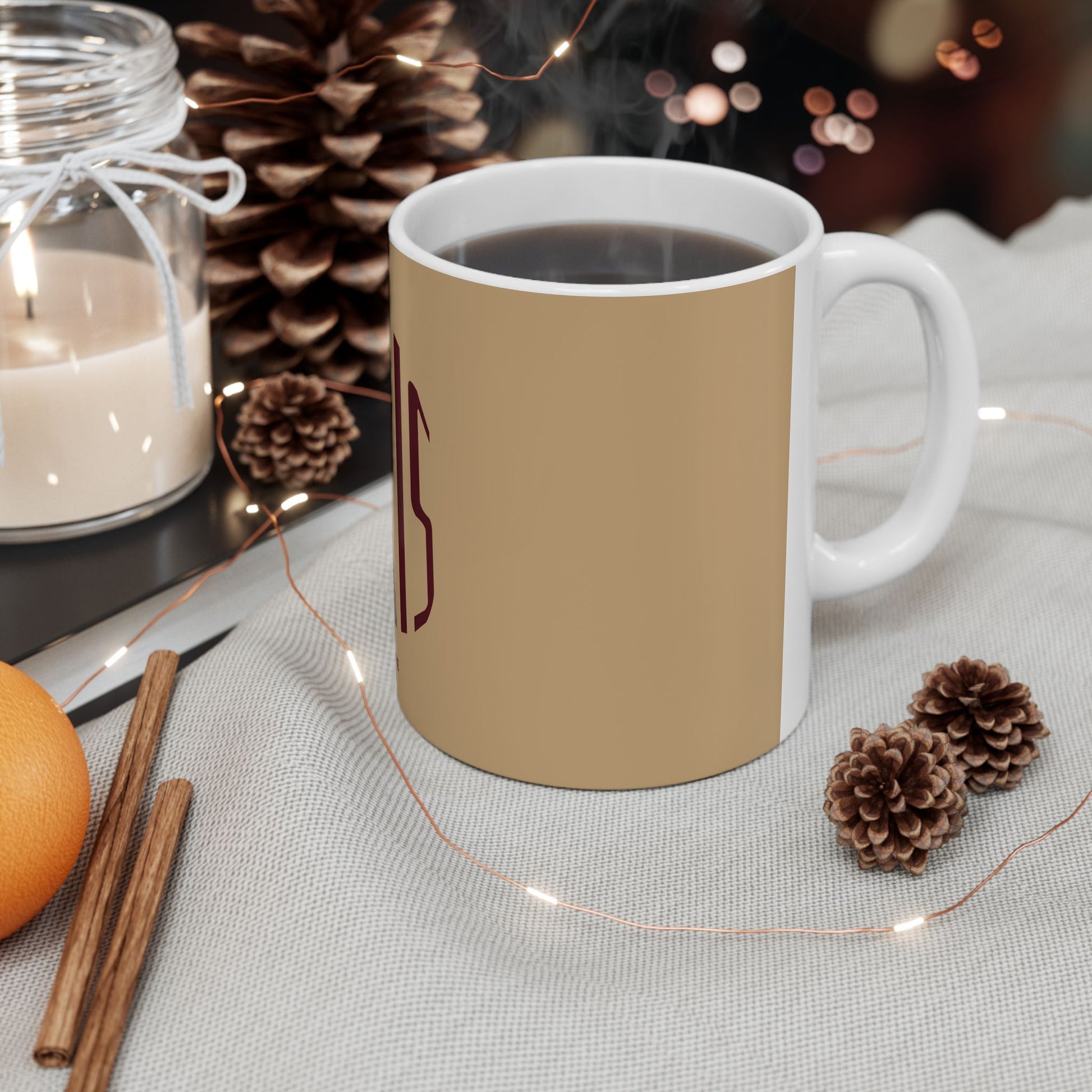 Beige mug with a logo on a table with decorative items