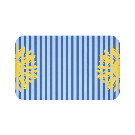 A rectangular mat with rounded corners featuring a blue and white vertical stripe pattern and yellow sunflower graphics on the left and right sides, shown on a plain white background.